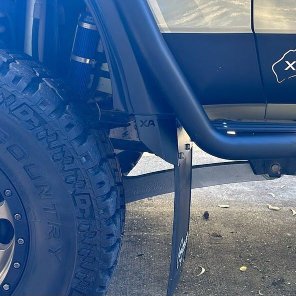 Close-up of a blue vehicle with a tire and suspension system on a concrete surface.