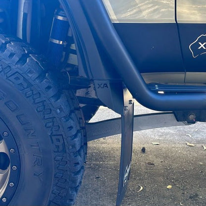 Close-up of a blue vehicle with a tire and suspension system on a concrete surface.