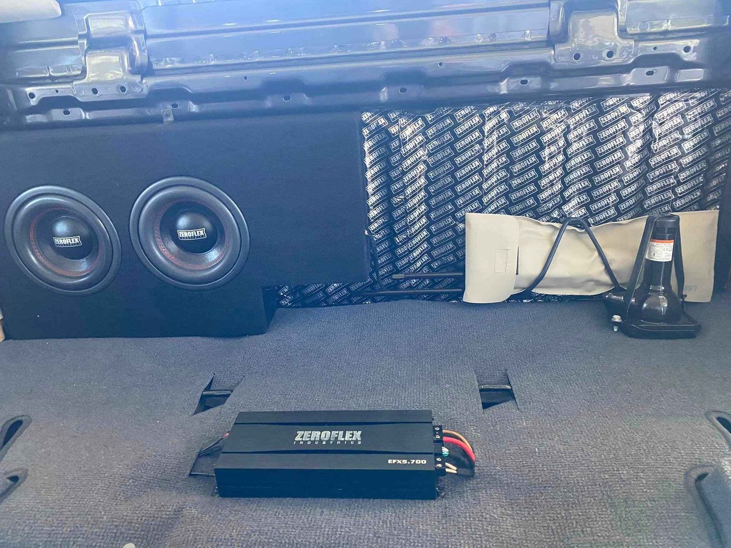 Car audio system with subwoofers and amplifier in a vehicle's cargo area.